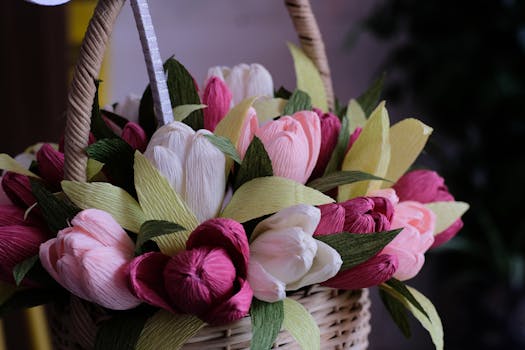 Panier en osier rempli de fleurs en papier aux couleurs pastel, idéal pour un cadeau personnalisé.